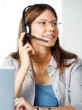 Foto: Junge Frau mit Headset beim Telefonieren